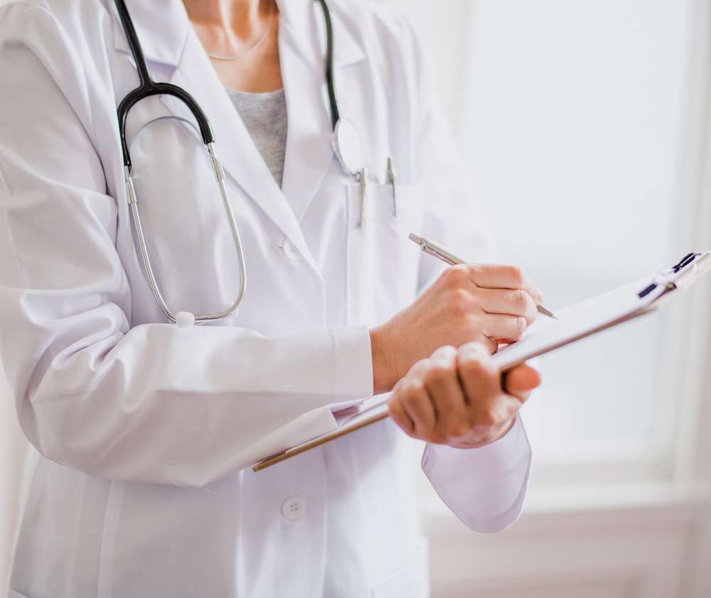 doctor reviewing chart Healthcare provider reviewing a patient's medical records and personalized treatment plan during a comprehensive wellness consultation