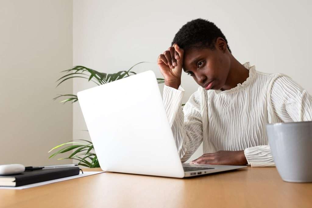woman experiencing burnout 101474558 YI Woman experiencing fatigue and difficulty concentrating while working at a laptop, representing brain fog and low energy addressed through personalized wellness optimization.